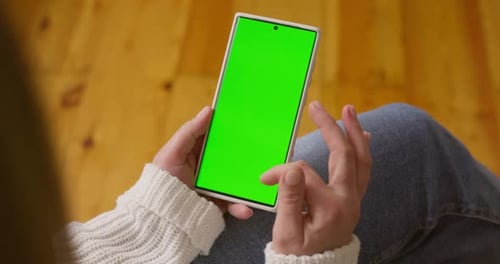 Closeup of Woman Hands Holding Smartphone with Green Screen in Vertical Position