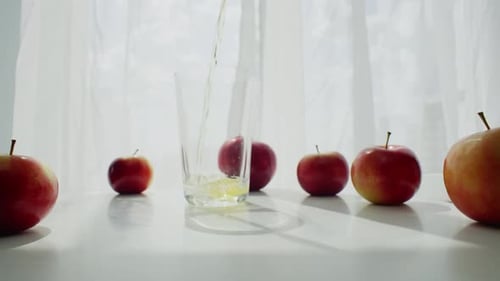 Pouring Fresh Organic Apple Juice Into a Glass