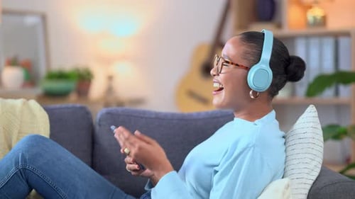 Woman on Couch with Phone and Headphones