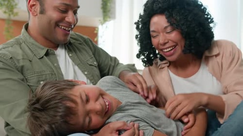 Happy Family Laughing and Playing Together at Home