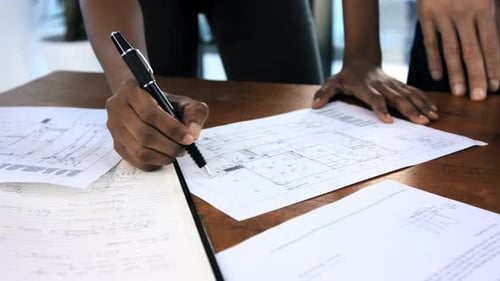 Colleagues Reviewing Blueprints in Modern Office