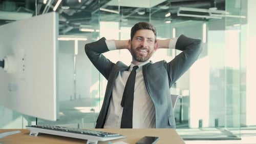 Man Celebrates Success at Computer in Modern Office