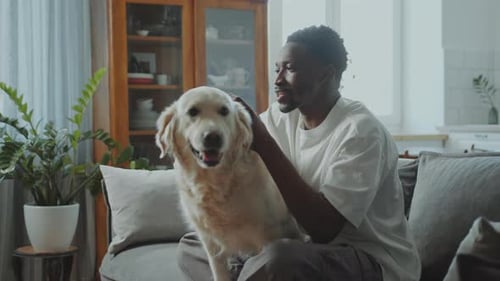 Young Adult Gaming With Pet Dog on Couch