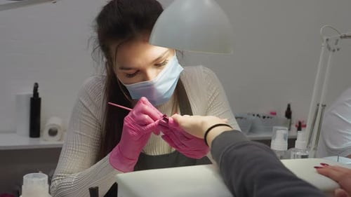 Woman Giving Manicure in a Bright Nail Salon