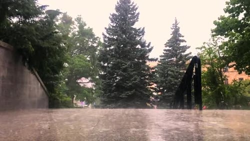 Regentag, Blick auf den Fußgängerweg bei mäßigem Regen und bewölktem Wetter.