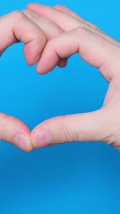 Hands Make Heart Shape on Blue Background