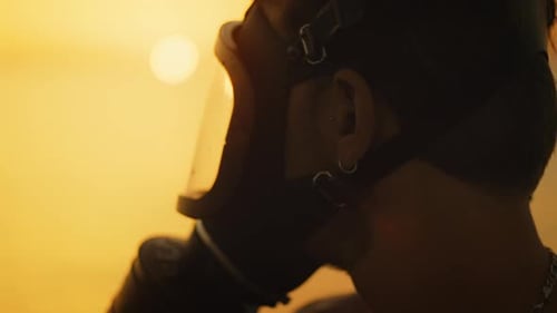 Man in Gas Mask Looks to Golden Horizon