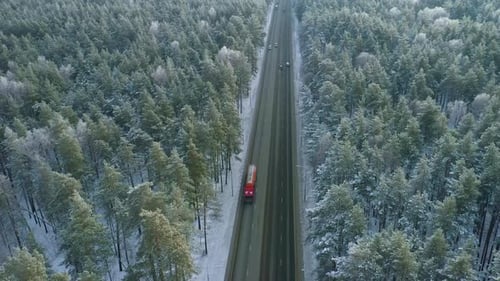 Driving Through a Snowy Forest Road with Vehicles on a Winter Day