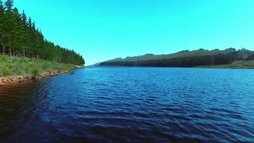4K aerial drone footage of a tranquil dam and surrounding land