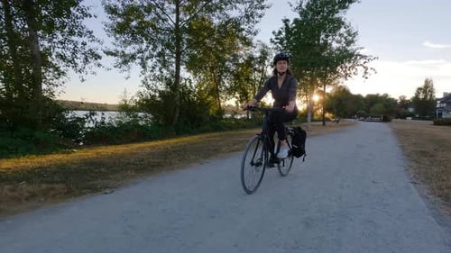 Adventure Woman Bike Riding on a Bicycle Trail Surrounded By Green Trees