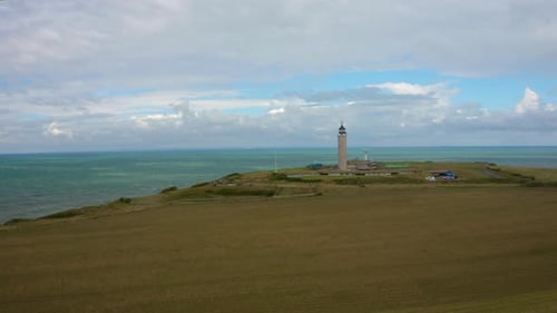 Blick von oben auf den Uferrand mit einem Leuchtturm am Ufer. l