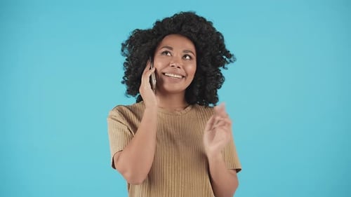 Smiling African American Woman is Having a Nice Conversation with Her Friend on the Phone A Woman is