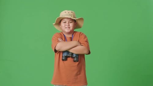 Asian Tourist Boy Researcher Crossing Arms, Smiling On Green Screen Background
