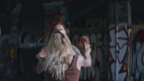 Women Fighting in Graffiti Covered Urban Setting