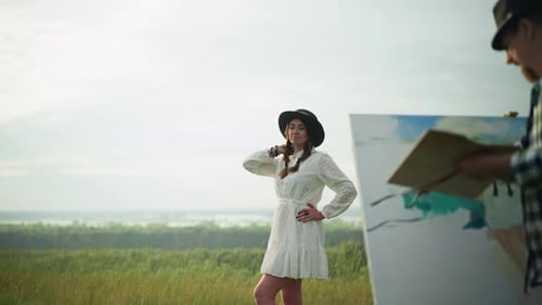 Woman Posing in White Dress As Artist Paints in Serene Grassy Field with Palette