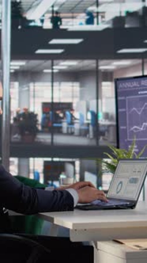 Vertical Video Business Leader Studying KPIs on Laptop and Tablet for Financial Management