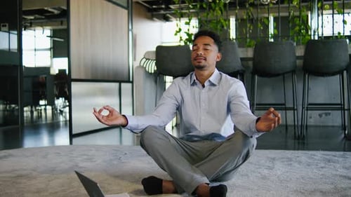 In a Modern Office a Businessman Practices Mindfulness and Meditation Blending Tranquility with