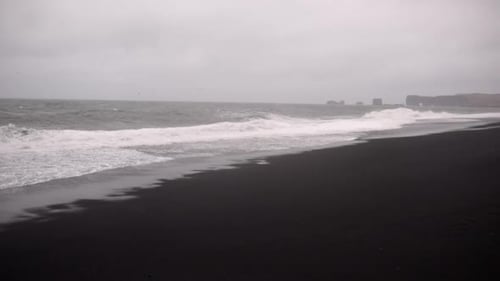 A Black Sandy Beach Surrounded By Some Mountains in Iceland