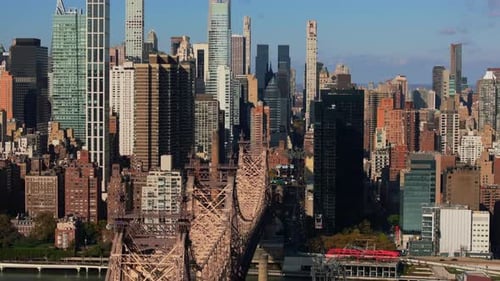 Roosevelt Island Tramway Crossing East River Next to Queensboro Bridge with Skyscrapers of Upper