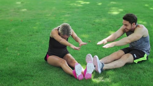 Young couple embracing healthy lifestyle training together in summer park garden