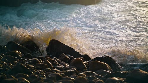 Waves Hitting Beach Rocks in Morning Sunlight