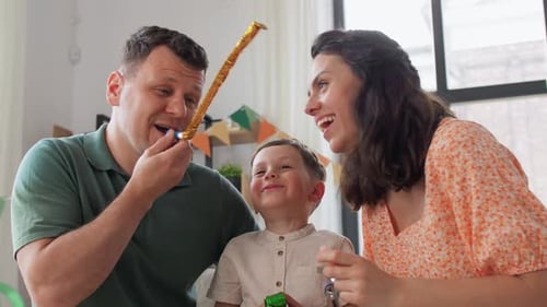 Family Celebrating Birthday with Party Blowers and Gifts