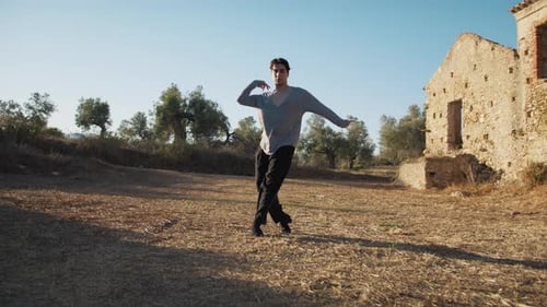 Man Dances in Rural Field By Ruins