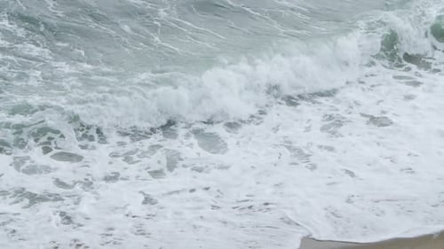 Waves Crashing on Sandy Beach Coastline