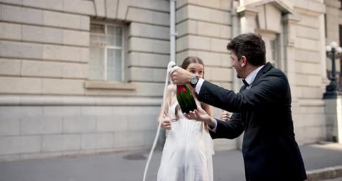Joyful Couple Celebrating Wedding by Popping Champagne