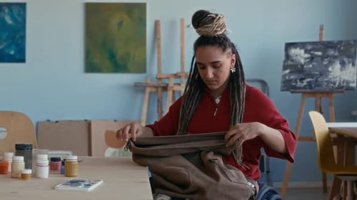 Portrait of Female Artist in Wheelchair Preparing to Paint in Cozy Studio
