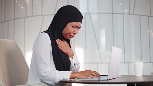 Business Woman in Hijab Coughing From Sore Throat During Office Work on Laptop