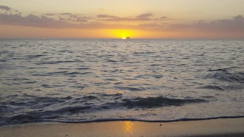 Lebendiger Sonnenuntergang über dem Meereshorizont mit Dramatisch Wolkenlandschaft und warmen Sonnenstrahlen, die die Wasseroberfläche beleuchten