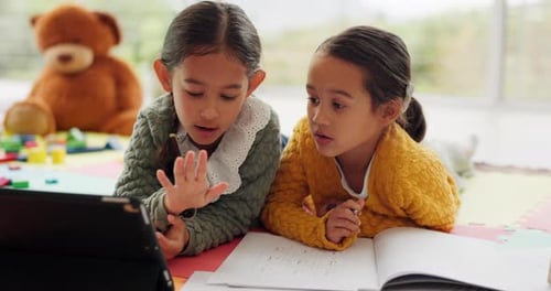 Two Young Girls Study Together in a Home
