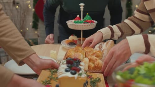 Close up of family serving foods on table to celebrate christmas party.