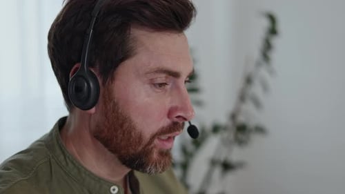 Focused Man with Headset Speaking in Home Office