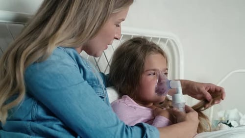 Woman Assists Child With Nebulizer Treatment at Home