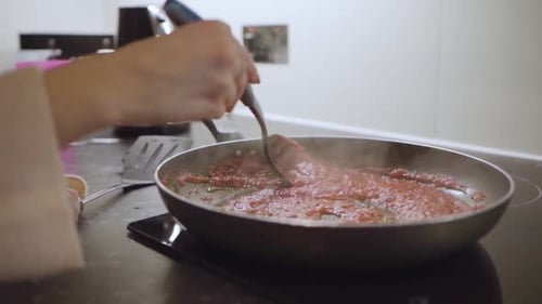 Stirring Tomato Sauce on Electric Stove