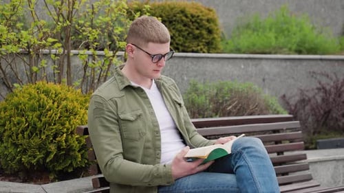 Kerl liest ein Buch im Park