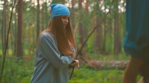 Lady Playfully Drops Bag on Grassy Ground in Scenic Forest