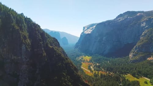 Green sunny valley among the cliff rocks of Yosemite National Park, California, United States.