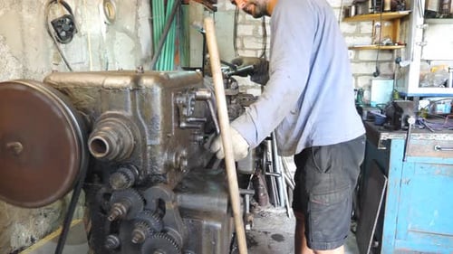 Adult Man Working with Old Workbench in His Garage or Workshop