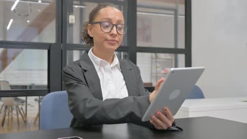 Woman Working on Tablet in Modern Office