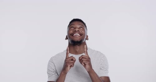 Souriez, homme heureux pointé vers le haut et sur fond blanc pour une promotion ou une annonce