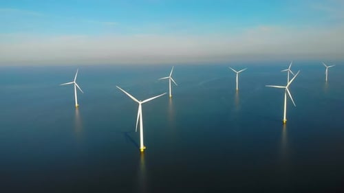 Windmühlenturbinen auf See aus einer Drohnen-Luftaufnahme von oben in einem riesigen Windmühlenpark