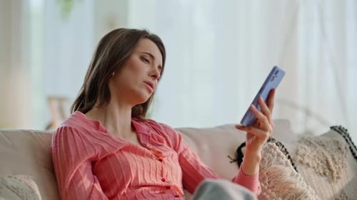 Woman Using Cell Phone, Frustrated, Sitting on Couch