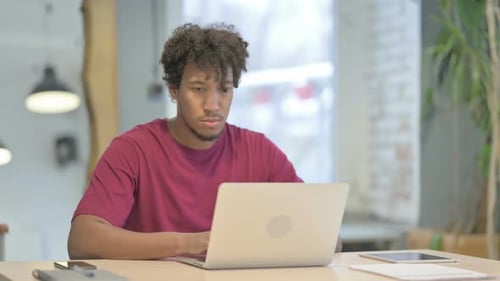 Busy African Man Typing on Laptop in Office
