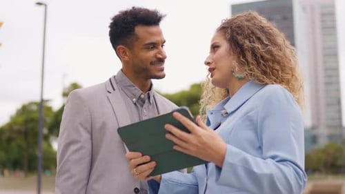 Business Colleagues Discussing a Tablet Outside Office Building
