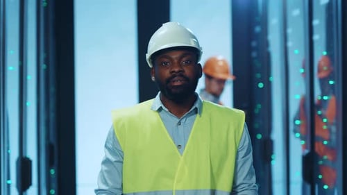 A Construction Worker Displays a Tablet While Working in a Data Center Environment Today