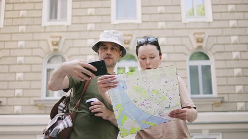 Couple Looks at Map in City