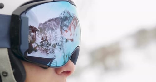 Portrait of a smiling skier on vacation in the mountains, behind her you can see the snow-covered
